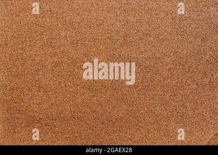 Sandpaper texture background where you can see the red-brown sand grain pattern on the sandpaper, suitable as a background for inserting text. Copy Sp Stock Photo