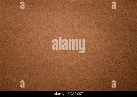 Sandpaper texture background where you can see the red-brown sand grain pattern on the sandpaper, suitable as a background for inserting text. Copy Sp Stock Photo