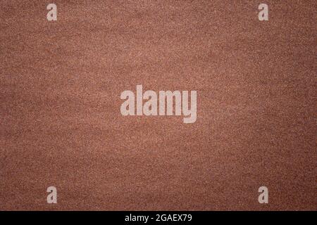 Sandpaper texture background where you can see the red-brown sand grain pattern on the sandpaper, suitable as a background for inserting text. Copy Sp Stock Photo