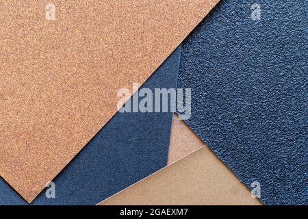 The background of the sandpaper surface, where the grains of sand on the sandpaper can be seen, and the difference in colors on the sandpaper indicate Stock Photo