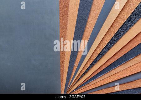 The background of the sandpaper surface, where the grains of sand on the sandpaper can be seen, and the difference in colors on the sandpaper indicate Stock Photo