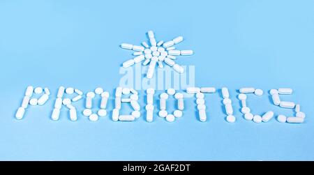 The word probiotics and the sun is laid out of white tablets on a blue background. The concept of medicine, healthy intestines Stock Photo