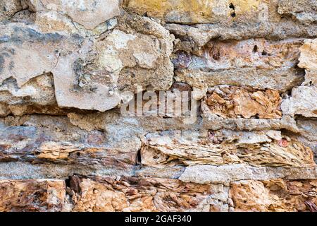Old cracked weathered plastered brick wall background texture. Dirty peeled plaster wall with falling off flakes of paint Stock Photo