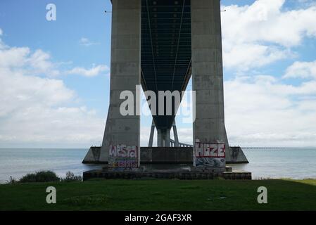 LISBOA, PORTUGAL - Jul 03, 2021: The pillars of the Vasco da Gama bridge against the cloudy sky Stock Photo