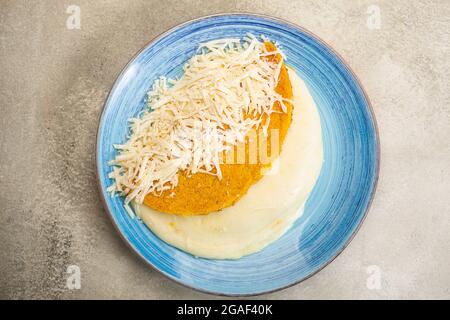 Arepa stuffed with cheese on a plate prepared from cornmeal, traditional cuisine of Colombia and Venezuela Stock Photo