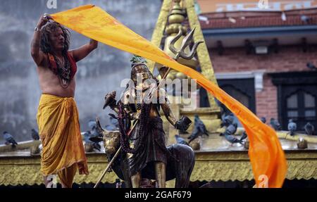 Kathmandu, Bagmati, Nepal. 30th July, 2021. A Hindu priest blows conch