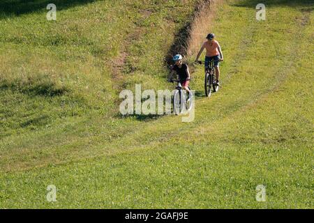 Two girls on mtb bikes. Mother and daughter riding on a trail. Stock Photo