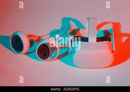Virtual reality helmet and controllers on white background in neon light. VR, future, gadgets, technology concept. Stock Photo