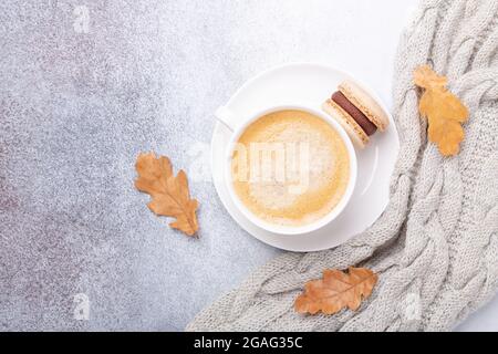 Cup of coffee, sweater and macarons on stone background. Copy space. Flat lay, top view - Image Stock Photo
