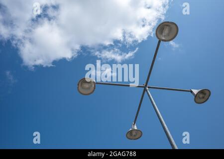 Low angle view of street lamp post against blue sky and cloud. Stock Photo