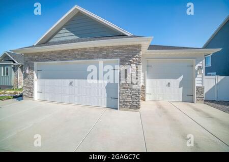 Three car garage exterior with stone veneer and green board and batten ...
