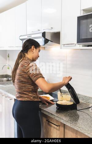 Woman prepare waffles in the kitchen Stock Photo