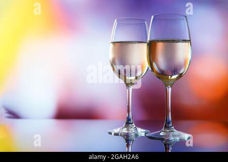 Two glasses of champagne against the background of multi-colored lights. Stock Photo