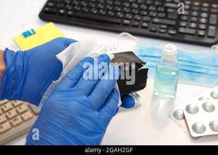 Office space wiping corona virus cleaning and disinfection of your workspace. Disinfecting wipes to wipe surface of keyboard, mouse at office. Stock Photo