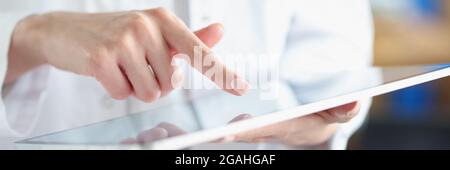 Medical officer doctor points his finger at tablet Stock Photo