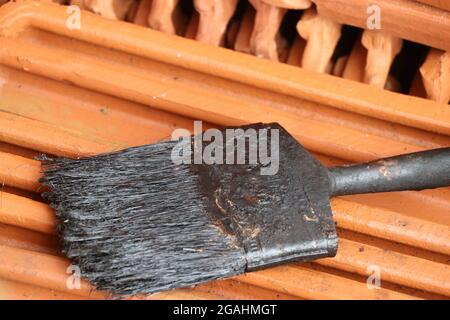 Very old and dirty paint brush left uncleaned after painting job. Used paint brush Stock Photo