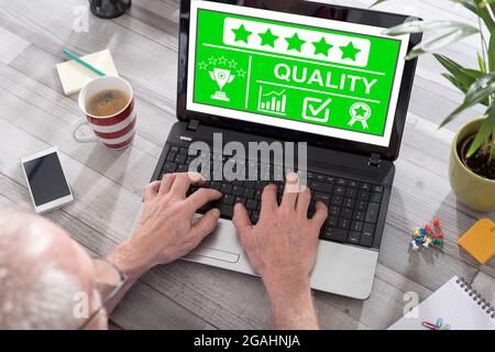 Quality concept shown on a laptop used by a man Stock Photo