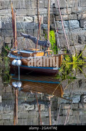 traditional wooden yacht, wooden sailing boat, clinker built sailing boat, wooden yacht reflected in water, traditional wooden clinker built yacht. Stock Photo