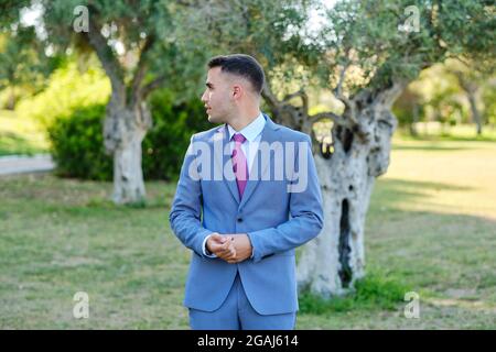Confident young businessman walking through a garden. The owner of a small business Stock Photo