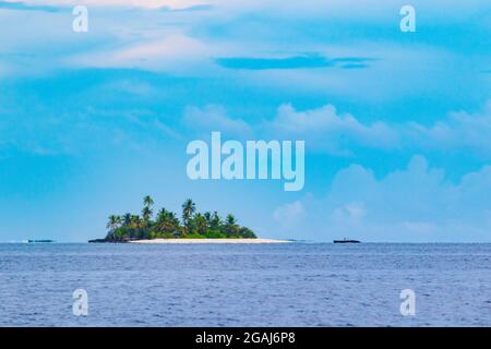 Small island in tropical sea against sky with clouds background.The Laccadive Sea or Lakshadweep Sea is a body of water bordering India, the Maldives, Stock Photo