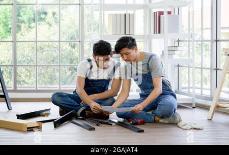 Two carpenters discussed the type of bench being assembled. Handyman installing wooden bench in new house. House renovation service. Morning work atmo Stock Photo