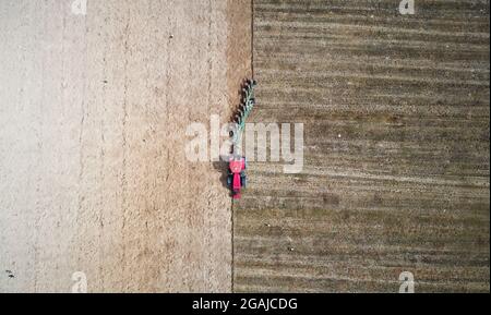 Farmer filed with tractor and plow aerial drone top view Stock Photo