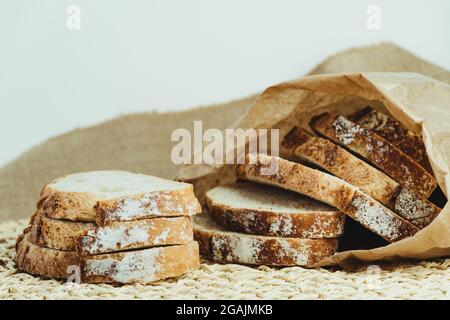 Sourdough bread with crispy crust cut into slices inside a paper bag ...