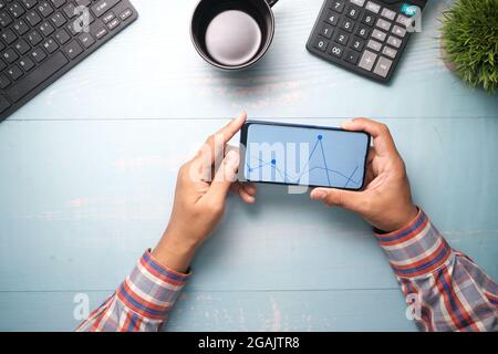 young man analyzing stock chart on smart phone  Stock Photo
