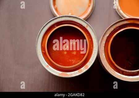 closeup the open orange paint can over out of focus brown background. Stock Photo