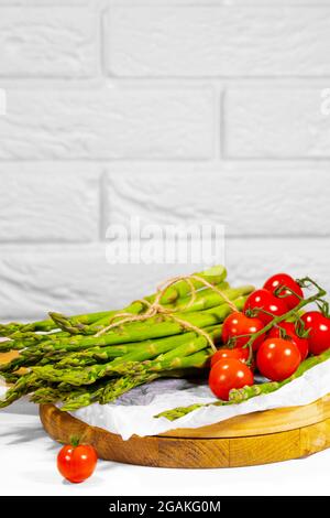 Asparagus and Tomato. Fresh harvest, traditional italian cuisine and foods. Healthy vegetarian food. Fresh raw organic vegetables, market. Vegan Stock Photo