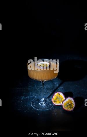 Passion fruit martini on dark background Stock Photo