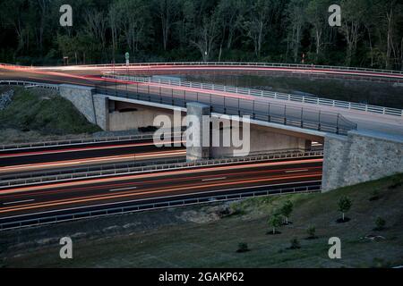 The new Pudding Street overpass on the Taconic State Parkway in Putnam County, New York. A slow camera shutter speed causes the car lights to streak. Stock Photo