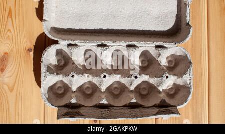 Grey egg carton without eggs on white background. egg carton box made from recycled paper with abstract repeated design pattern Stock Photo