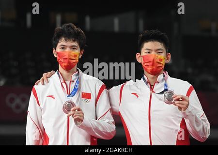 Tokyo, Japan. 31st July, 2021. Li Junhui (L) /Liu Yuchen of China show their silver medals during the awarding ceremony of the badminton men's doubles match at the Tokyo 2020 Olympic Games in Tokyo, Japan, July 31, 2021. Credit: Guo Chen/Xinhua/Alamy Live News Stock Photo