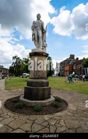 A statue of Admiral Lord Nelson standing on a tall plinth in the grounds of Norwich Cathedral Stock Photo