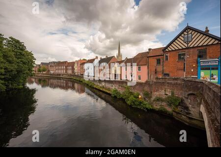 The River Wensum  in Norwich taken from Fye Bridge with houses and norwich cathedral in the background on a warm sunny day Stock Photo