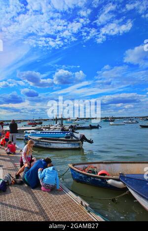 Vertical image of  Children happily crab fishing of a jetty by the sea Stock Photo