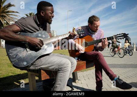 Fellow musician and friend Nog (right) joining Tom Sibanda (left) on a quest to raise funds to pay his rent on the last day of the month. Stock Photo