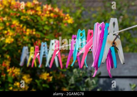 clothes pegs, washing line, rusty clothes pegs, pegs left out on washing line, colourful plastic clothes pegs on a washing line, brightly coloured peg Stock Photo