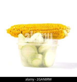 Yellow sweet corn with chopped zucchini in plastic bowl isolated on a white. Stock Photo