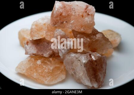 Blocks of pink himalayan salt on white plate cut-out. Stock Photo