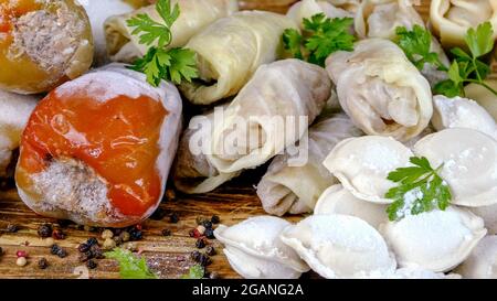 Frozen semi-finished products, stuffed bell peppers, cabbage rolls and dumplings lies on counter in market or on table in the home kitchen. Dolly shot Stock Photo