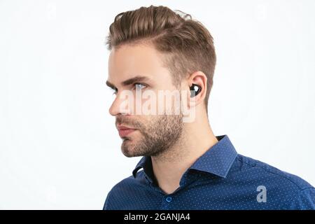 handsome unshaven man with wireless bluetooth earphones isolated on white, bluetooth technology Stock Photo