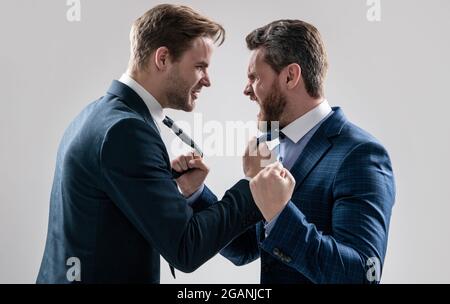 two angry businessmen punching in fight and arguing having struggle, aggressive negotiations. Stock Photo