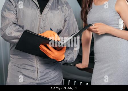 Auto Mechanic explains vehicle repair invoice to female customer and signing papers Stock Photo