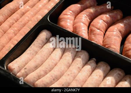 Fresh assorted sausages for preparation barbecue grill in black package. BBQ. Festive summer barbecue party. Outdoors. Close up. Stock Photo