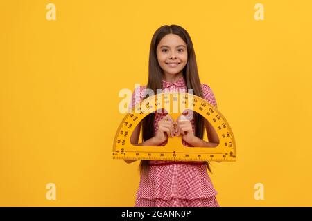 cheerful teen girl study math in school hold protractor ruler, geometry Stock Photo