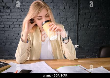 Woman reads documents drinking coffee Stock Photo