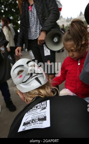 London, UK. 31st July, 2021. A protester wears an anonymous mask during the demonstration.Children and their parents protest in Central London against continued Covid-19 restrictions and vaccination of children. (Photo by Martin Pope/SOPA Images/Sipa USA) Credit: Sipa USA/Alamy Live News Stock Photo