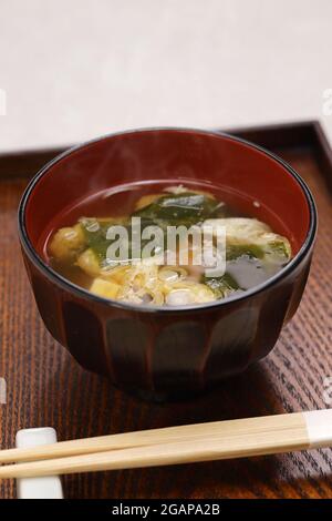 Japanese miso soup, additional ingredients such as green onion, wakame seaweed, and fried tofu. Stock Photo